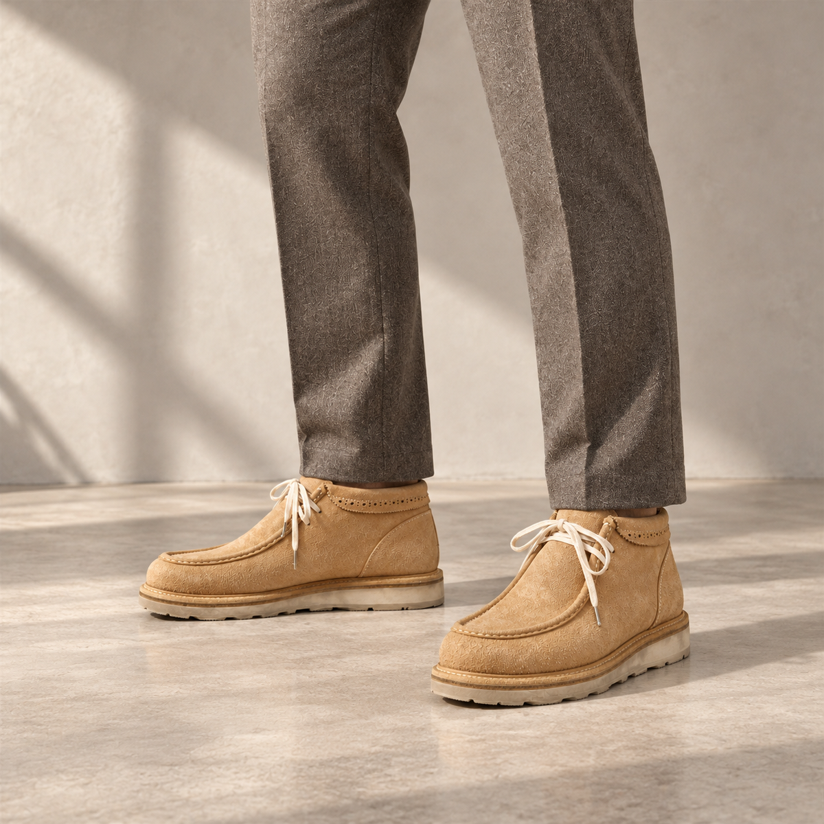 AI styling visualization: both PASCH Millstone caramel-brown men's chukka boots fully visible with taupe tailored trousers, square composition.